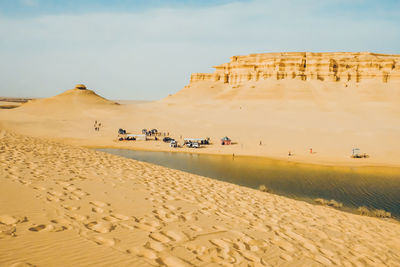 Scenic view of desert against cloudy sky