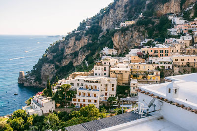 High angle view of buildings and rocky mountains by sea at positano