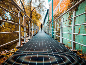 Rear view of woman walking on elevated walkway