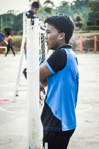 Side view of young man standing at playground