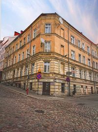 Street by building in city against sky