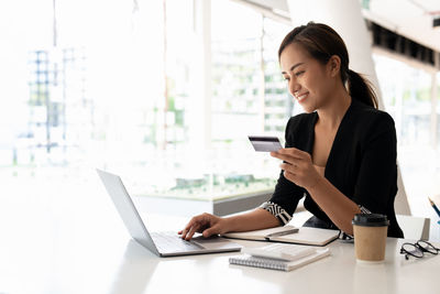 Young woman using laptop at table