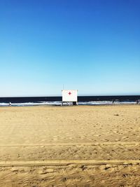 Scenic view of beach against clear blue sky