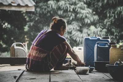 Rear view of woman sitting at table