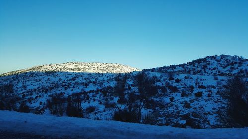 Snowcapped mountains against clear blue sky