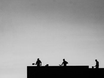 Silhouette men against clear sky