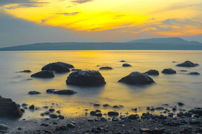 Rocks on the beach during sunrise in banyuwangi, indonesia.