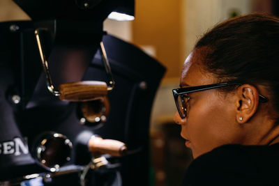 Side view of thoughtful young woman wearing eyeglasses in cafe