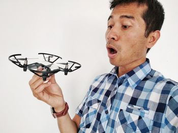 Man holding drone against white background