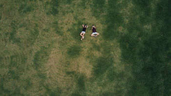 High angle view of women lying in grass