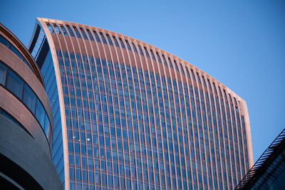 Low angle view of modern building against clear blue sky