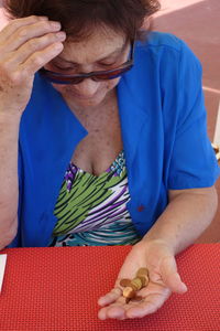 Retired elderly woman holding some coins in her hand