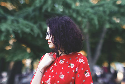 Rear view of woman standing against blurred trees