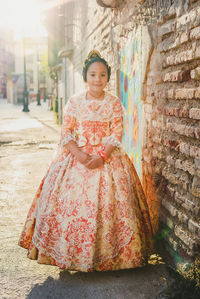 Portrait of smiling girl standing against wall