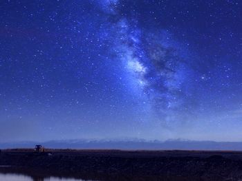 Scenic view of landscape against star field at night