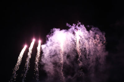 Low angle view of fireworks against sky at night