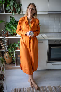 Portrait of young woman standing by window