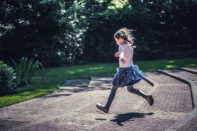 Girl running down wide steps outdoors 