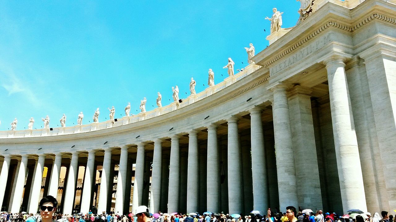 architecture, famous place, large group of people, built structure, travel destinations, tourism, building exterior, travel, international landmark, history, tourist, low angle view, architectural column, capital cities, clear sky, person, sculpture, sky, blue