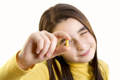 Close-up portrait of woman holding hands over white background