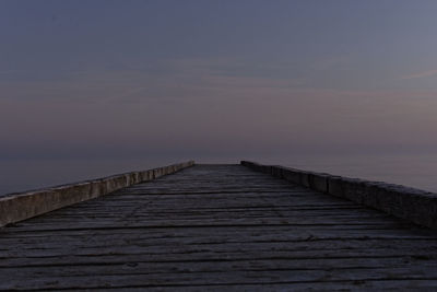 Wooden pier over sea against sky