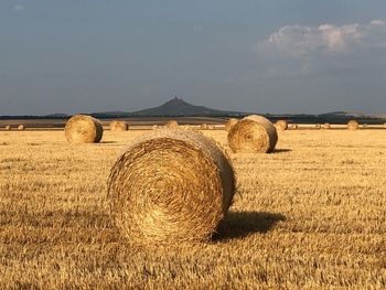 Hay bales on field against sky