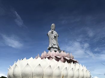 Low angle view of statue against building against sky