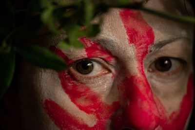 Close-up portrait of man with red eyes closed