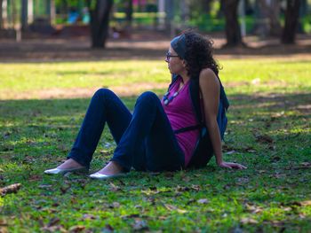Woman sitting on grass in field