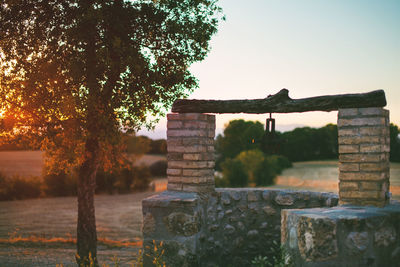 View of old well at sunset