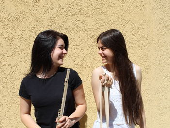 Beautiful young woman smiling against wall