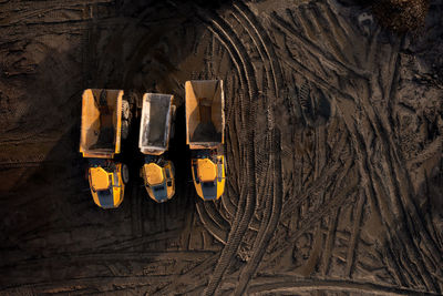 Aerial view above dumper truck or earth mover vehicle with muddy soil on construction site