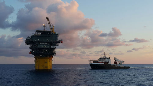 Ship in sea against sky during sunset