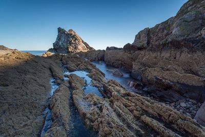 Low angle view of rocks by sea