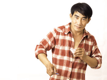 Portrait of man standing against white background