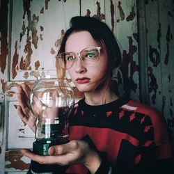 Portrait of a beautiful young woman holding a glass lamp