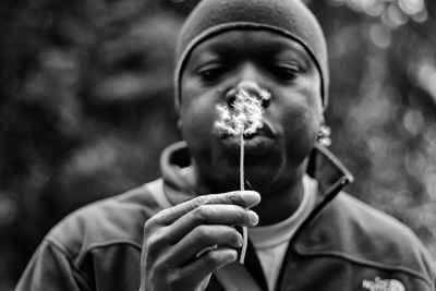 Man blowing dandelion seeds