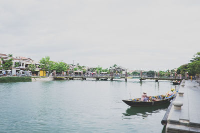 Scenic view of river against sky in city