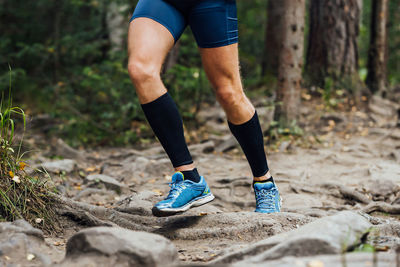 Low section of woman walking on dirt road