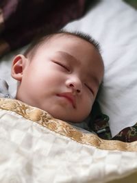 Cute baby boy sleeping on bed