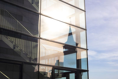 Low angle view of glass building against sky