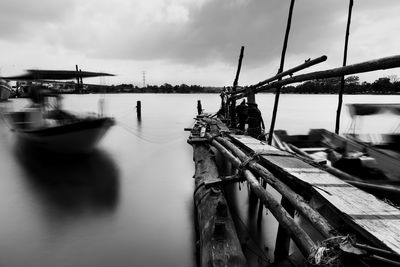 Wooden bridge jetty and fishing boat. slow motion in black and white