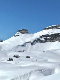 Scenic view of snowcapped mountains against clear blue sky