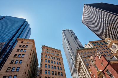 Low angle view of modern buildings against clear blue sky