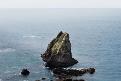 Rock formation in sea against sky