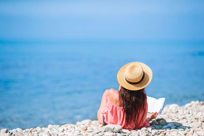 Rear view of woman wearing hat at beach