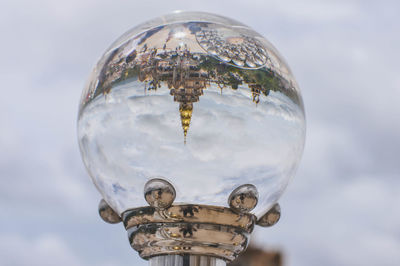 Close-up of crystal ball against sky