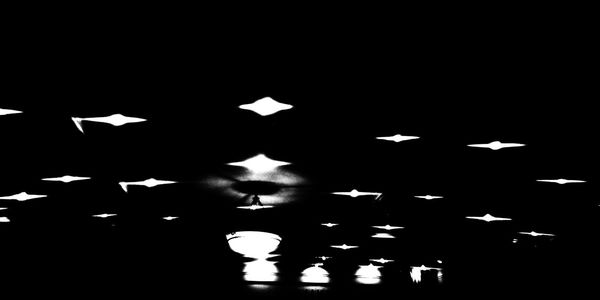 Low angle view of illuminated lights against sky at night