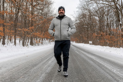 Full length of man standing on road during winter