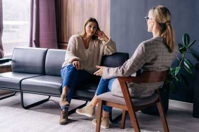 A young woman in a consultation with a psychologist listens to advice on improving behavior in life. 